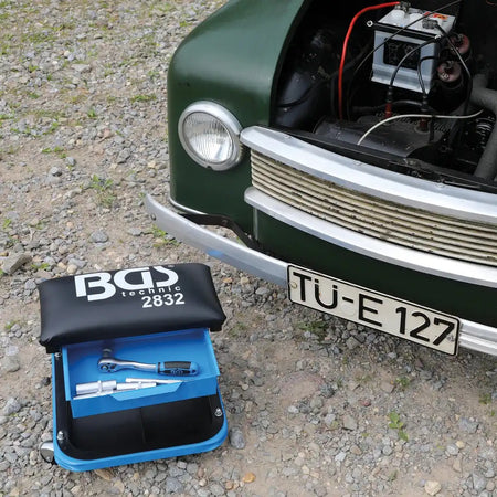Bild eines Werkstatt-Rollsitzes vor einem Oldtimer fotografiert